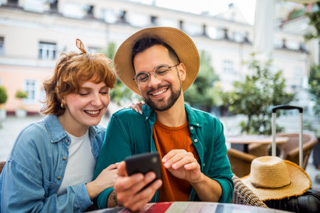 Tourist couple taking a break in cafe from exploring the city. They use their phones.