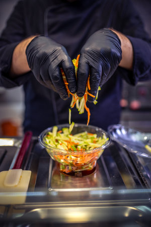 Chef in the kitchen making delicious looking salad.