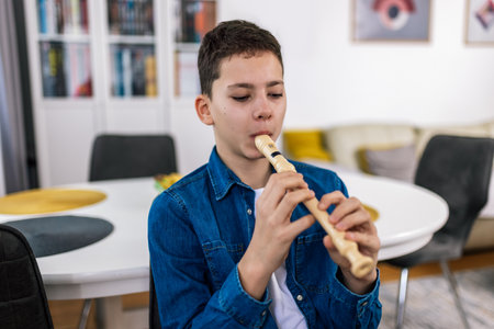 Boy plays flute at home.の写真素材