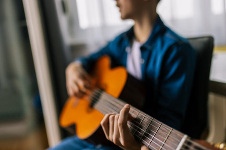 Boy plays guitar at home.の写真素材
