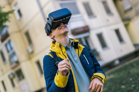 A young boy walking down a city street wearing VR glasses, fully immersed in a virtual experienceの写真素材