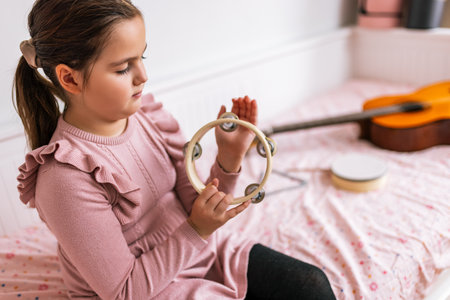 Little girl playing tambourine.の写真素材