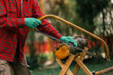 Man cutting wood with hand saw, dust and movements.の写真素材