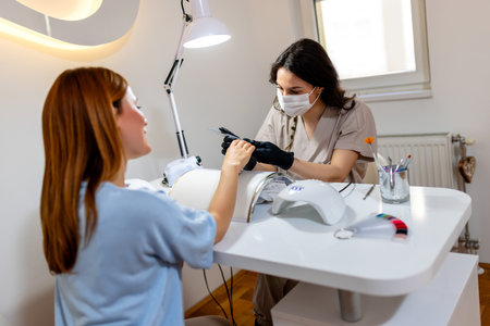 Manicurist filing client's nails at the beauty salon.の写真素材