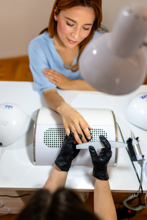 Manicurist filing client's nails at the beauty salon.の写真素材