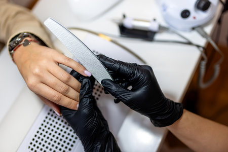 Manicurist filing client's nails at the beauty salon.の写真素材