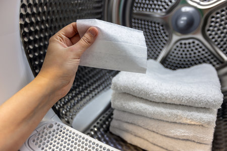 Tumble dryer wipes. Women puts wipe in her towels so she can later iron easier.の写真素材