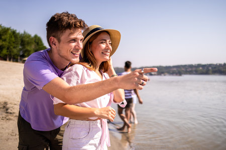 Young couple enjoying quality time together on a beautiful beach. They are relaxed, happy, and fully...