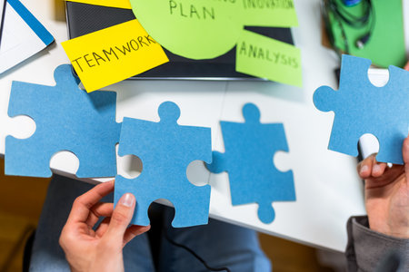 A business man at home, carefully assembling a puzzle. The scene symbolizes problem-solving, strategic thinking,の写真素材