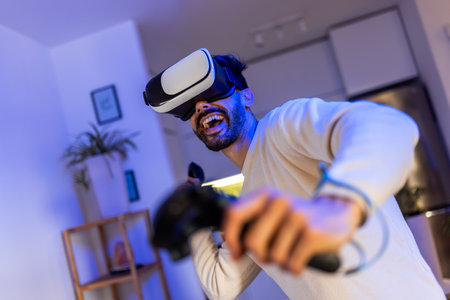 A young man is immersed in a video game experience using a virtual reality headset.の写真素材