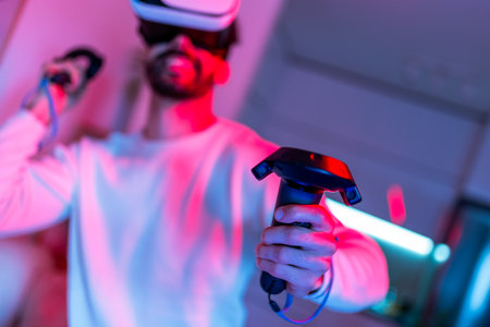 A young man is immersed in a video game experience using a virtual reality headset.の写真素材