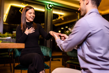 Man proposing to his girlfriend on a romantic date dinner in restaurant.の写真素材