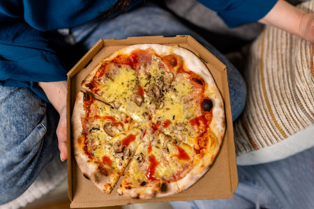 Womans's hand holding pizzaの写真素材