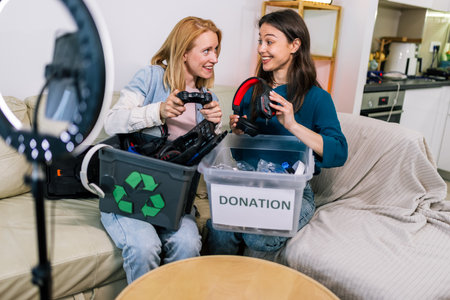 Two young girls are recording a video for social media. They are showing how to recycle old computer parts and explaining why it is important.の写真素材
