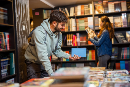 Young male is browsing bookshelves in a library.の写真素材
