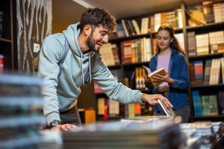 Young male is browsing bookshelves in a library.の写真素材