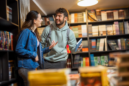 A young male and female student are browsing bookshelves in a library.の写真素材
