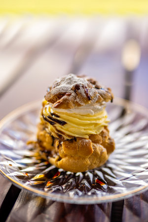 A plate of cream-filled profiteroles elegantly served on the terrace tableの写真素材