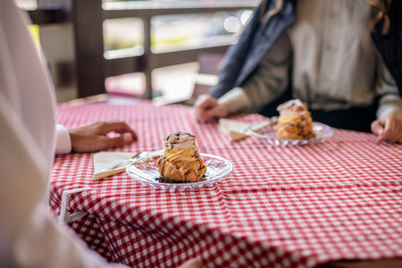 A plate of cream-filled profiteroles elegantly served on the terrace tableの写真素材