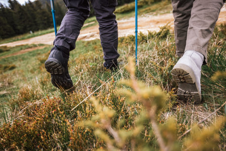 Close-up view of hiking boots on a rugged mountain trail, with breathtaking nature and mountains...