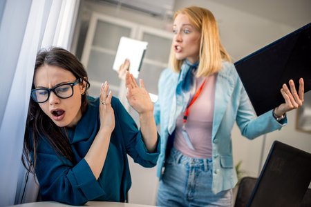 Female CEO aggressively yelling at her colleague in the office, showing workplace tension,...