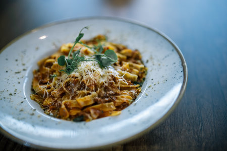 Classic Italian tagliatelle bolognese pasta served on a plate in a restaurant, rich meat sauce and fresh garnish.の写真素材