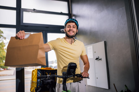 Courier with bicycle holds food package in hand while entering building, concept of fast delivery,...