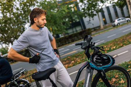Young man adjusts and repairs bicycle gear, concept of bike maintenance, cycling repair, outdoor...