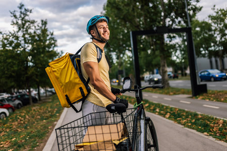 Food delivery courier riding bicycle in cityの写真素材