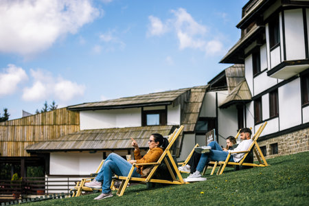 Hotel guests relaxing on loungers in autumnの写真素材