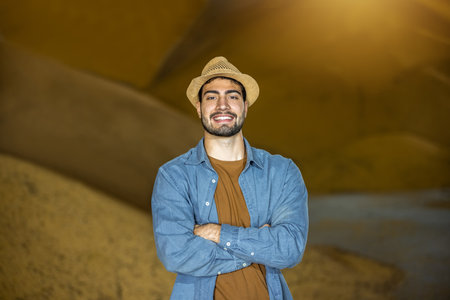 Young worker posing in front of soybean pile in warehouseの写真素材