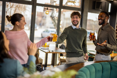 Cheerful friends clinking glasses with drinks at bar counter in cafe