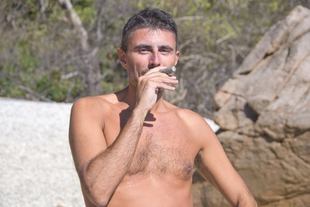 Man pretending to Smoke a Coral on a Beach, Australiaの写真素材