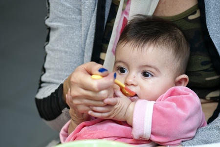 Baby Girl eating with her Mother, Italy