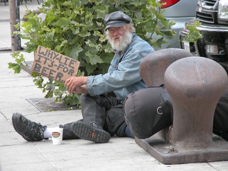 SAN FRANCISCO, U.S.A. - AUGUST 27: Unidentified tramp with a sign begs to buy Beer on August 27,2003 in Fisherman's Wharf, San Francisco, U.S.A. It is common in these streets to find a tramp but this one is a really playfulのeditorial素材