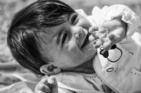 Baby Girl relaxing and playing on a Beach Towel, Italyの写真素材