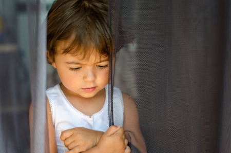Baby wiith her Thoughts behind the Curtainの写真素材