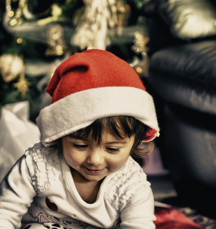 Baby with Christmas Hat playing indoor, Italyの写真素材