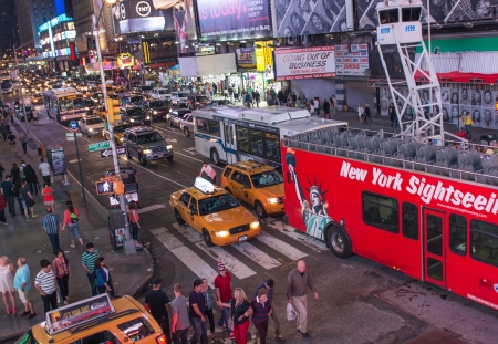 NEW YORK CITY - JUN 8: Famous Sightseeing red bus at night in Times Square traffic, June 8, 2013 in...