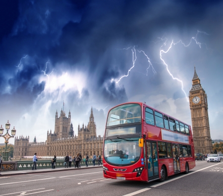 Double decker bus crossing Westminster Bridge with stormy weather.