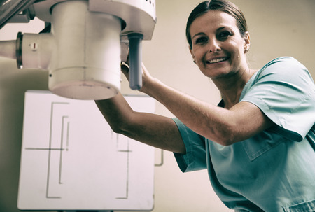 Young female doctor checking xray machine before a scan.の写真素材