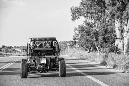 KOS, GREECE - MAY 7, 2014: Quad vehicle speeds up in island road. Quad is the preferred transportation vehicle for tourists on the island..のeditorial素材
