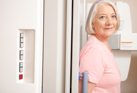 Senior female woman in 60s undergoing x-ray scan.