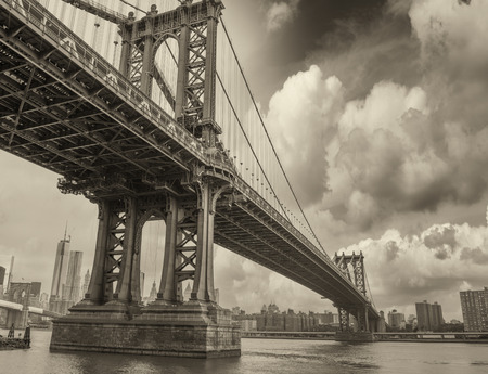 Cloudy evening in New York with Manhattan Bridge side view and city skyline.の写真素材