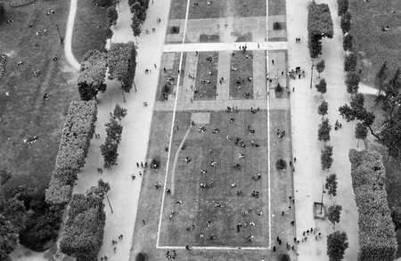 Crowd of tourists relaxing in Champs de Mars gardens, under the Eiffel Tower, Paris - France.の写真素材