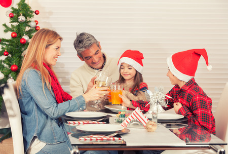 Family Christmas table with tree. Parents and children celebrating.の写真素材
