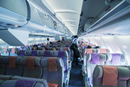 DUBAI, UAE - JULY 30, 2010: Tourists take a seat on a Emirates flight. Emirates is the largest...