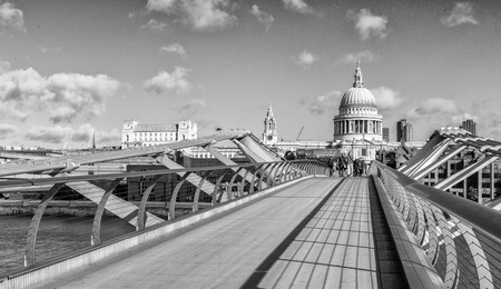 LONDON - SEPTEMBER 28, 2012: Tourists enjoy the view of Millennium Bridge on a beautiful day. London attracts more than 15 million people every year.のeditorial素材