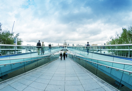 LONDON - SEPTEMBER 28, 2012: Tourists enjoy the view of Millennium Bridge on a cloudy day. London attracts more than 15 million people every year.のeditorial素材