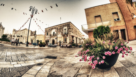 APULIA, ITALY - AUGUST 23, 2012: Locals and tourist enjoy a small town square in the evening. Apulia is one of the most visited region of Italy.のeditorial素材